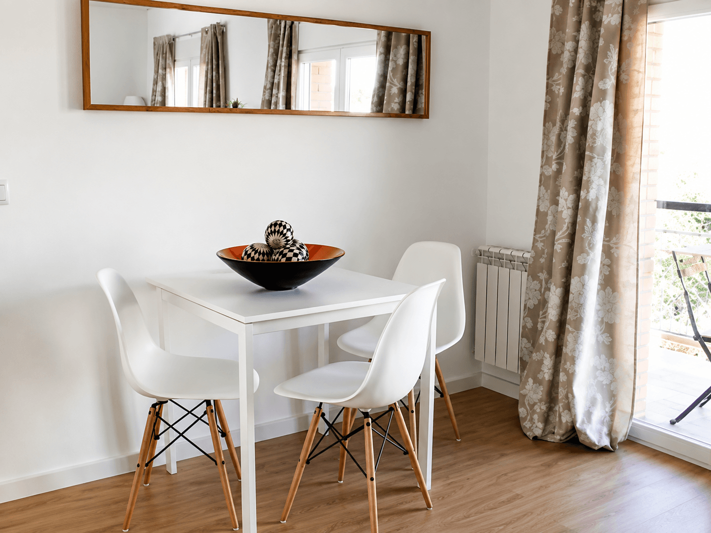 Salón comedor después de la reforma, con suelo de madera y paredes claras